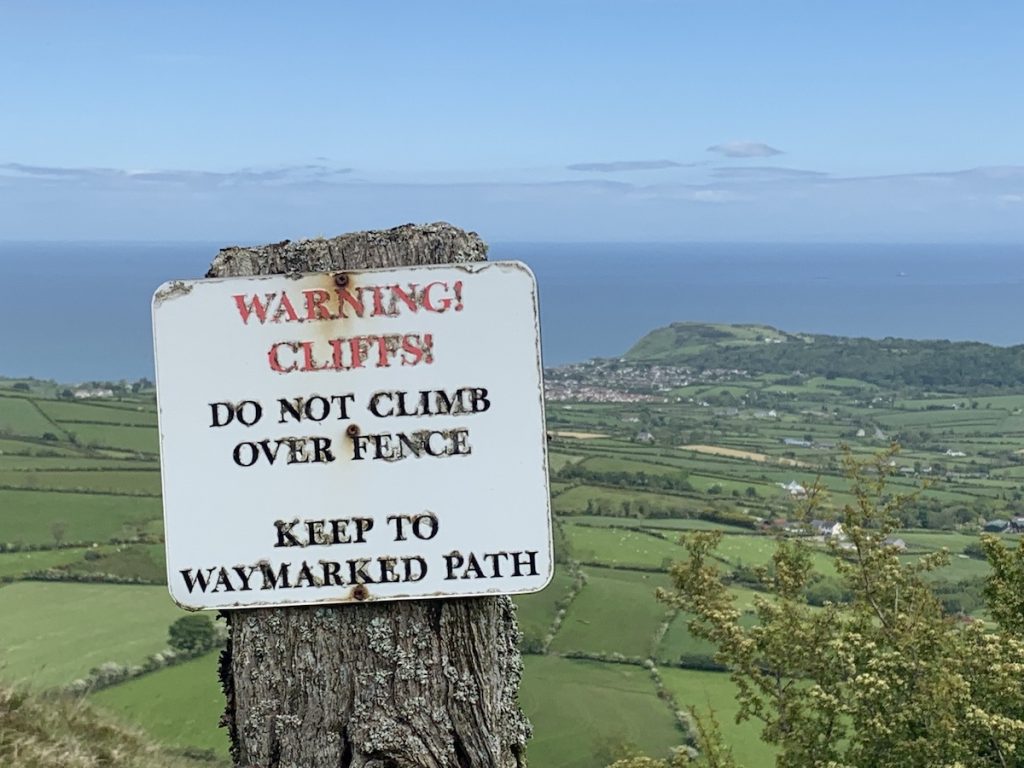 sallagh braes walk viewed from cliff top with warning cliffs sign looking out over the Irish sea