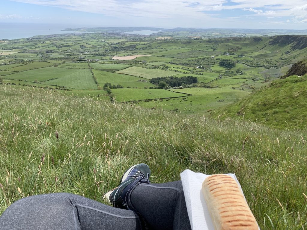 casual picnic looking out over the grass on the sallagh braes walk toward ballygally and the irish sea