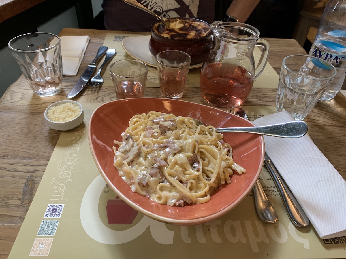 plate of pasta, moussaka and two glasses of wine