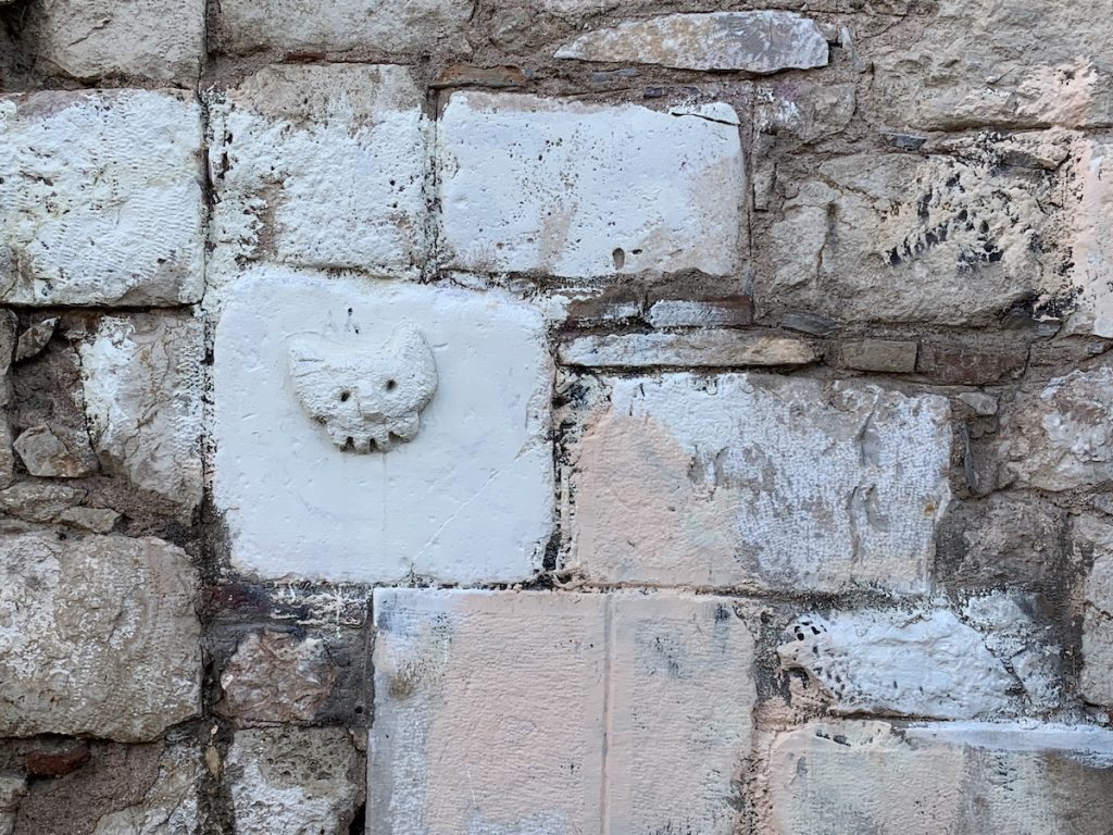 sculpture of cat head in a block set into a wall